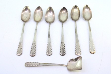 Conjunto de seis colheres de chá e pá de açúcar em prata com relevos espinhados.